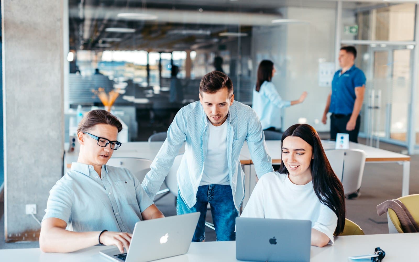 Stock photo of colleagues collaborating on laptops in an office
